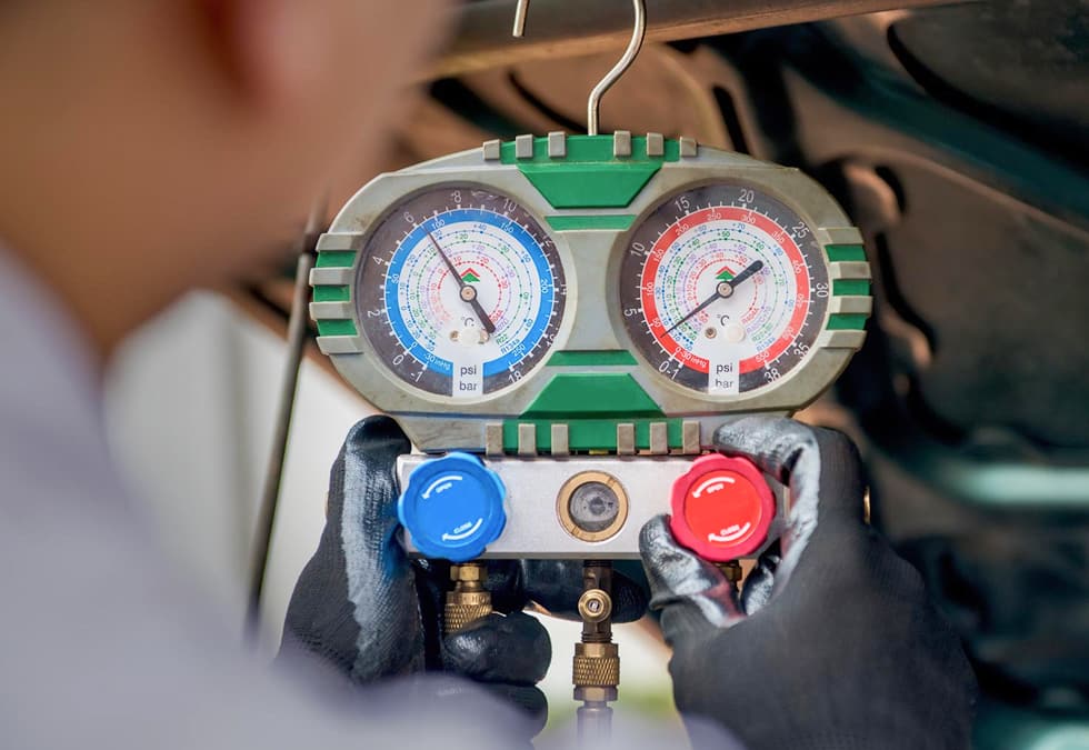 Klimaanlagen Wartungsgerät Mit Druckmessern Und Ventilen In Mechanikerhand