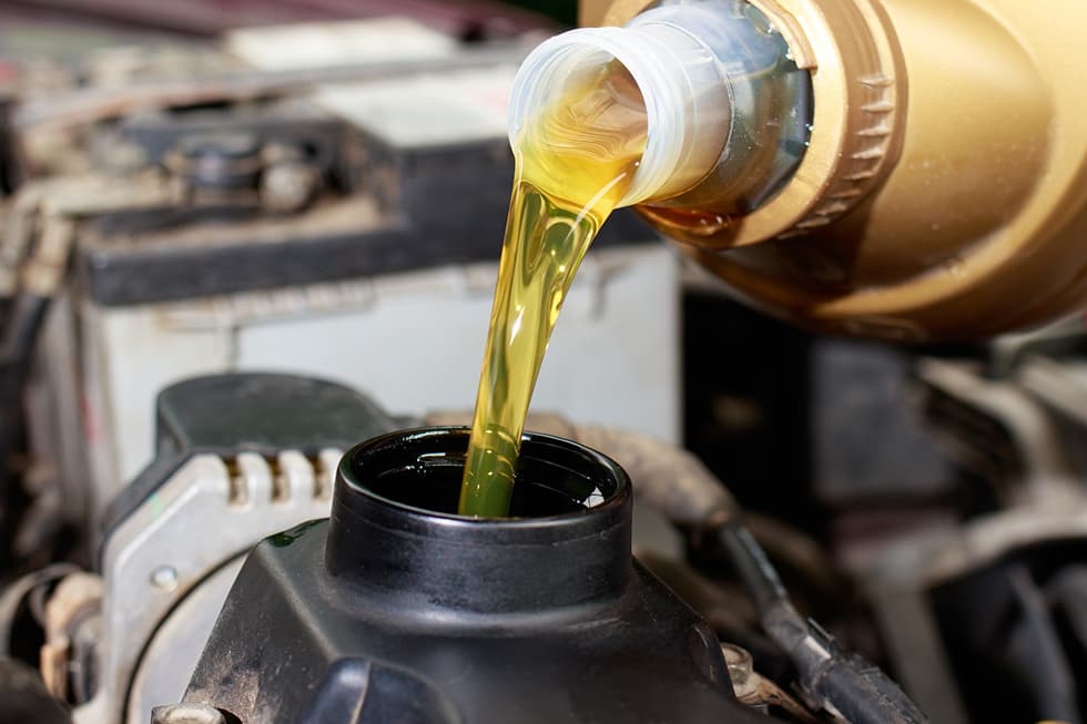 Motoröl Wird Aus Flasche In Automotor Eingefüllt Motoröl Wird Aus Flasche In Automotor Eingefüllt